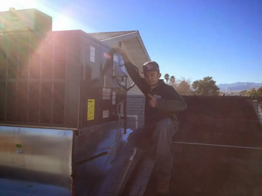 HVAC technician performing AC Tune-Up on a rooftop unit in Indianola